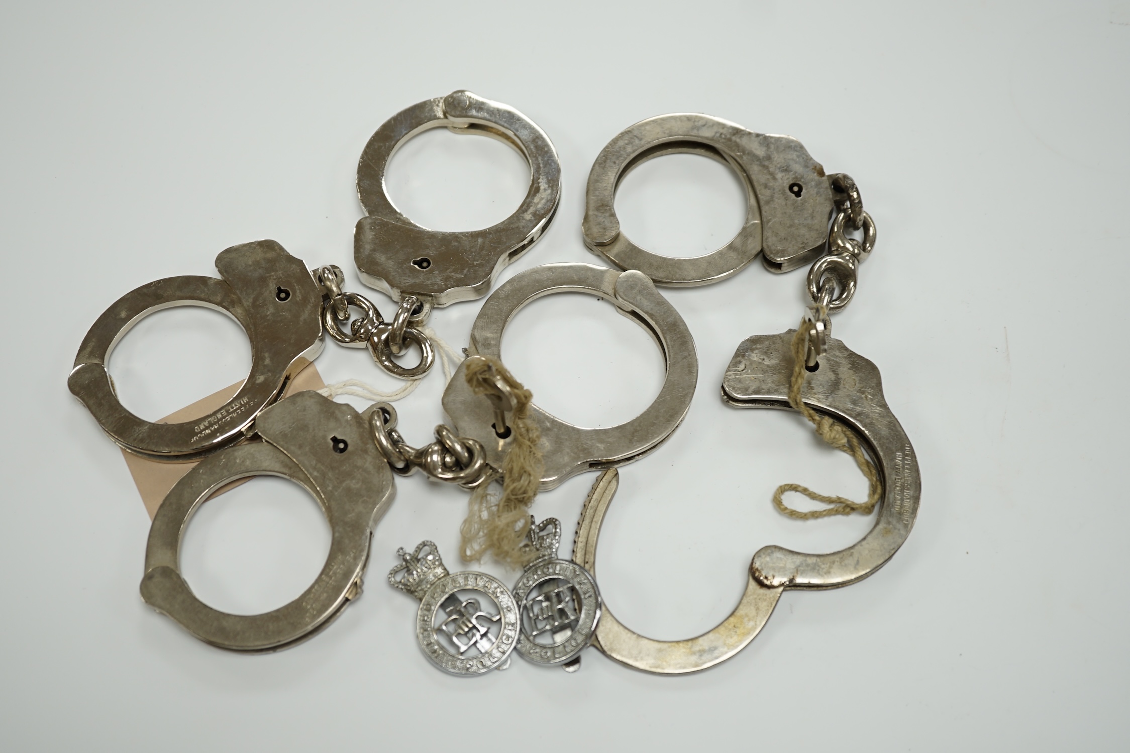 Three handcuffs, two with keys and two Metropolitan Police badges